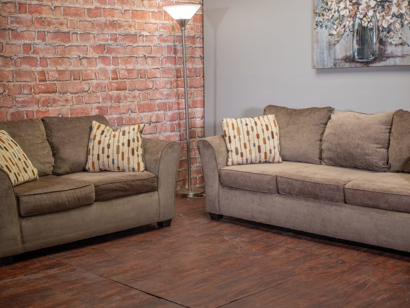 Brown couch and loveseat next to each other