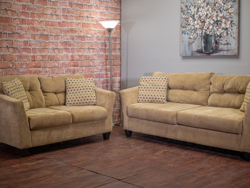 Sandy brown couch and loveseat next to each other