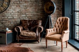 Old furniture sitting in a brick room with hardwood floors